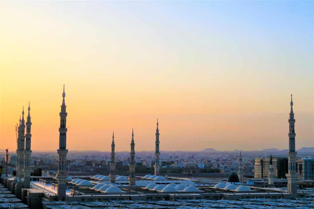 Sunset over city skyline with minarets.