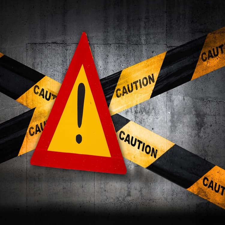 Yellow caution sign with warning tapes on concrete.