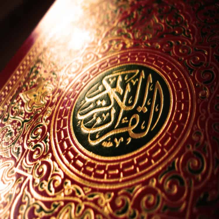 Gold-embossed Quran cover with Arabic calligraphy.