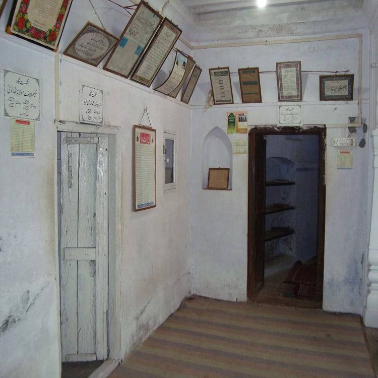 Historic room with Islamic texts and traditional arch doorway.